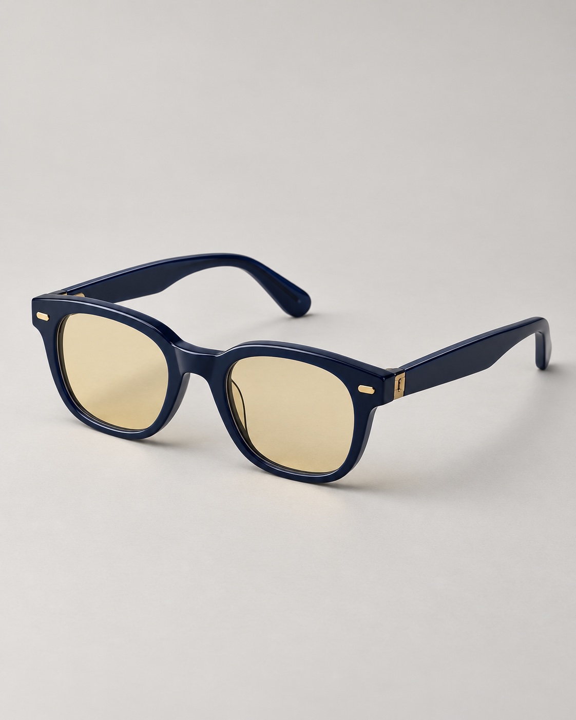 Isolated commercial studio product photograph of deep navy acetate optical glasses with amber tint lenses