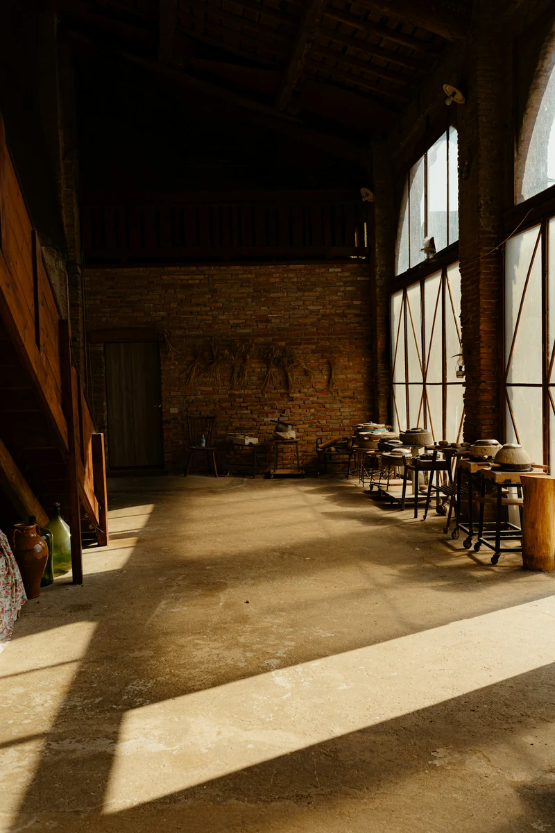 Illustrative reference: Sunlit studio interior with tall windows and warm natural materials